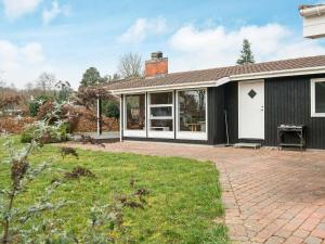 a black house with a brick yard in front of it at 6 person holiday home in Silkeborg in Silkeborg
