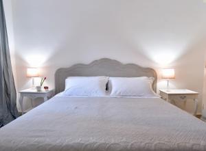 a bedroom with a white bed with two tables at Palazzetto Barnaba in Venice