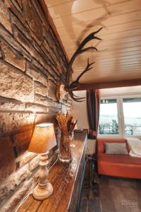a lamp on a table in a room with a stone wall at Le Loup Gris - 35 pers - Vue-Wellness, Butgenbach-Malmedy in Butgenbach