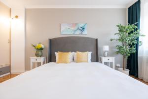a bedroom with a large white bed with yellow pillows at Haga Flat in Oradea