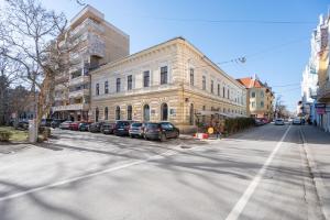 an empty street with cars parked in front of a building at Haga Flat in Oradea