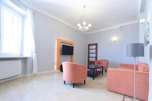 a living room with a couch and a table and chairs at Warsaw City Apartments in Warsaw