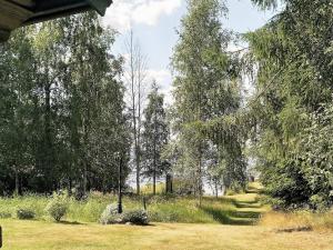 a path through a field with trees and grass at 6 person holiday home in GRANG RDE in Grangärde