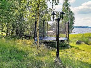 a lamp post in the grass next to a bench at 6 person holiday home in GRANG RDE in Grangärde