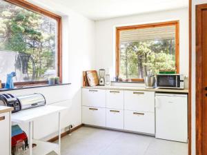 a kitchen with white cabinets and a window at 14 person holiday home in Sj llands Odde in Tjørneholm