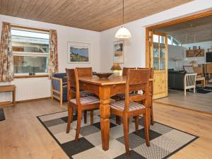 a dining room and living room with a table and chairs at 6 person holiday home in R nde in Rønde