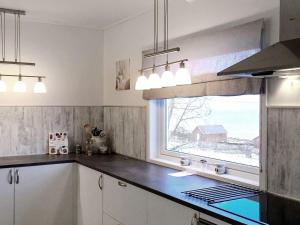 uma cozinha com um lavatório e uma janela com vista em Holiday home Svensby III em Svensby