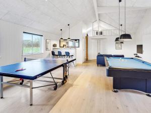 a room with a pool table and ping pong tables at 20 person holiday home in Stege in Stege