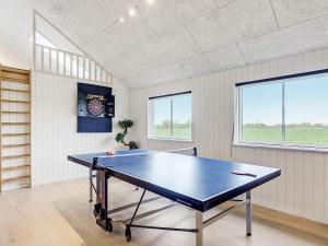 a ping pong table in a room with windows at 20 person holiday home in Stege in Stege