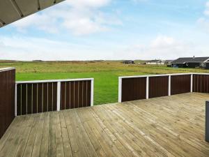 a wooden deck with a view of a field at 8 person holiday home in Harbo re in Harboør