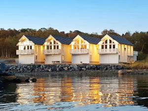 une rangée de maisons à côté d'une masse d'eau dans l'établissement Holiday home Brattvåg, à Brattvåg
