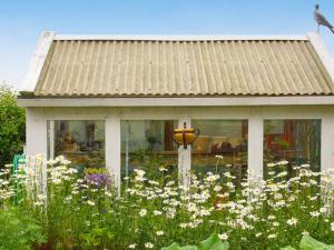 a house with a garden with flowers in front of it at 6 person holiday home in SIMRISHAMN in Simrishamn