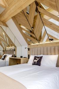 two beds in a room with wooden ceilings at Bańska Ostoja in Bańska Niżna