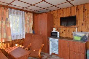 a room with a kitchen with a desk and a microwave at Ośrodek Wypoczynkowy Mewa in Mrzeżyno