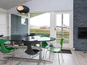 uma sala de jantar com uma mesa e cadeiras verdes em 6 person holiday home in Hejls em Hejls