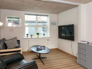 a living room with a couch and a tv at Holiday home Grenaa XXIII in Grenå