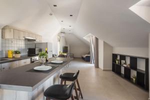 a large kitchen with a counter and chairs in it at Fidias city rooms in Argostoli