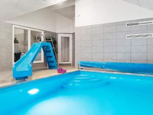 a swimming pool with a blue slide in a room at 18 person holiday home in Hasselberg in Kappeln
