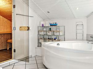 a white bathroom with a tub and a shower at 7 person holiday home in Kalundborg in Kalundborg