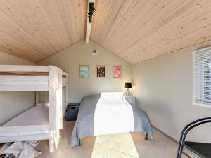 a bedroom with two bunk beds and a wooden ceiling at Holiday home Væggerløse LXXI in Marielyst