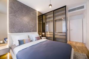 a bedroom with a large bed and a glass wall at Bucharest Luxury Apartments in Bucharest