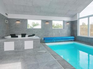 a bathroom with a swimming pool and a tub at 16 person holiday home in Glesborg in Glesborg