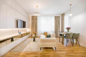 Bucharest Luxury Apartments في بوخارست: غرفة معيشة مع أريكة وطاولة