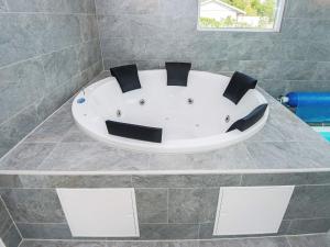 a white bath tub in a bathroom with a stone wall at 16 person holiday home in Glesborg in Glesborg