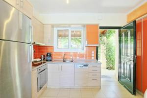 a kitchen with a sink and a refrigerator at Beach Villa Blue by PosarelliVillas in Barbati