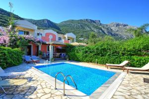 a swimming pool in front of a house at Beach Villa Blue by PosarelliVillas in Barbati