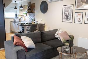 een woonkamer met een grijze bank en een keuken bij STYLISH URBAN OASIS in Zagreb +17 foto's