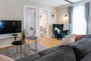 een woonkamer met een bank en een televisie bij STYLISH URBAN OASIS in Zagreb