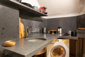 a kitchen with a washing machine and a sink at Bail Mobilite Luxe Le Marais in Paris