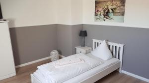Gasthof Pritzier في Pritzier: سرير أبيض في غرفة مع صورة على الحائط