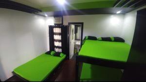 a room with two green beds in a room at Casa Demetria Duplex Hot Spring Resort Laguna in Pansol