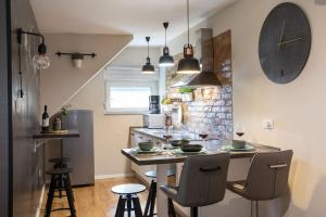 een keuken met een tafel en stoelen en een klok bij STYLISH URBAN OASIS in Zagreb