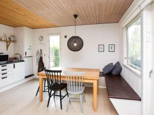 een keuken en eetkamer met een houten tafel en stoelen bij 6 person holiday home in Slagelse in Slagelse