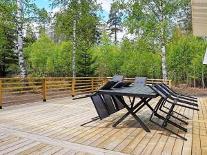 - une table de pique-nique et 2 chaises sur une terrasse en bois dans l'établissement 6 person holiday home in LOFTAHAMMAR, à Loftahammar