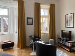 a living room with yellow curtains and a television at Apartment Vienna Smart Living in Vienna