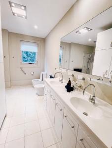 a bathroom with two sinks and a toilet and a mirror at Jewel of Brooklyn - Hawkesbury River Marina in Brooklyn