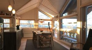 una cucina e una sala da pranzo con tavolo e alcune finestre di Venehovda - cabin at 1000 masl ad Ål
