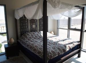 a bedroom with a canopy bed and a window at Elegant and comfortably furnished 2BRH apartment in a quiet area! in Dubai +19 photos