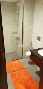 a bathroom with a shower and a toilet and a sink at Elegant and comfortably furnished 2BRH apartment in a quiet area! in Dubai
