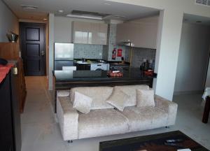 a living room with a couch and a kitchen at Elegant and comfortably furnished 2BRH apartment in a quiet area! in Dubai