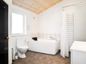 uma casa de banho branca com uma banheira e um WC em 8 person holiday home in Hirtshals em Hirtshals