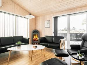 uma sala de estar com mobiliário preto e uma lareira em 8 person holiday home in Hirtshals em Hirtshals