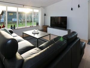 - un salon avec un canapé en cuir et une télévision dans l'établissement 6 person holiday home in Hadsund, à Hadsund