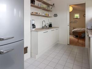 La cuisine blanche est équipée d'un évier et d'un réfrigérateur. dans l'établissement 6 person holiday home in Hadsund, à Hadsund