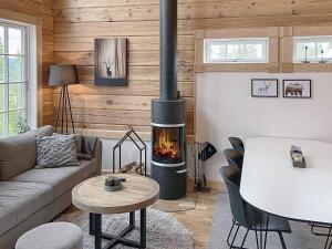 a living room with a fireplace and a table at 8 person holiday home in S LEN in Sälen