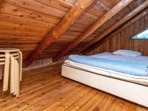 um quarto com uma cama num sótão de madeira em Holiday home Hovborg II em Hovborg